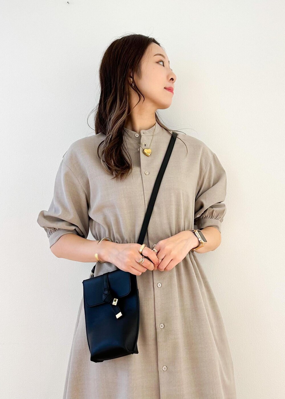 ブラック系のショルダーバッグ、ベージュ系のワンピース、ブラウン系のその他パンツを着用したレディースの夏コーディネートの4枚目の写真