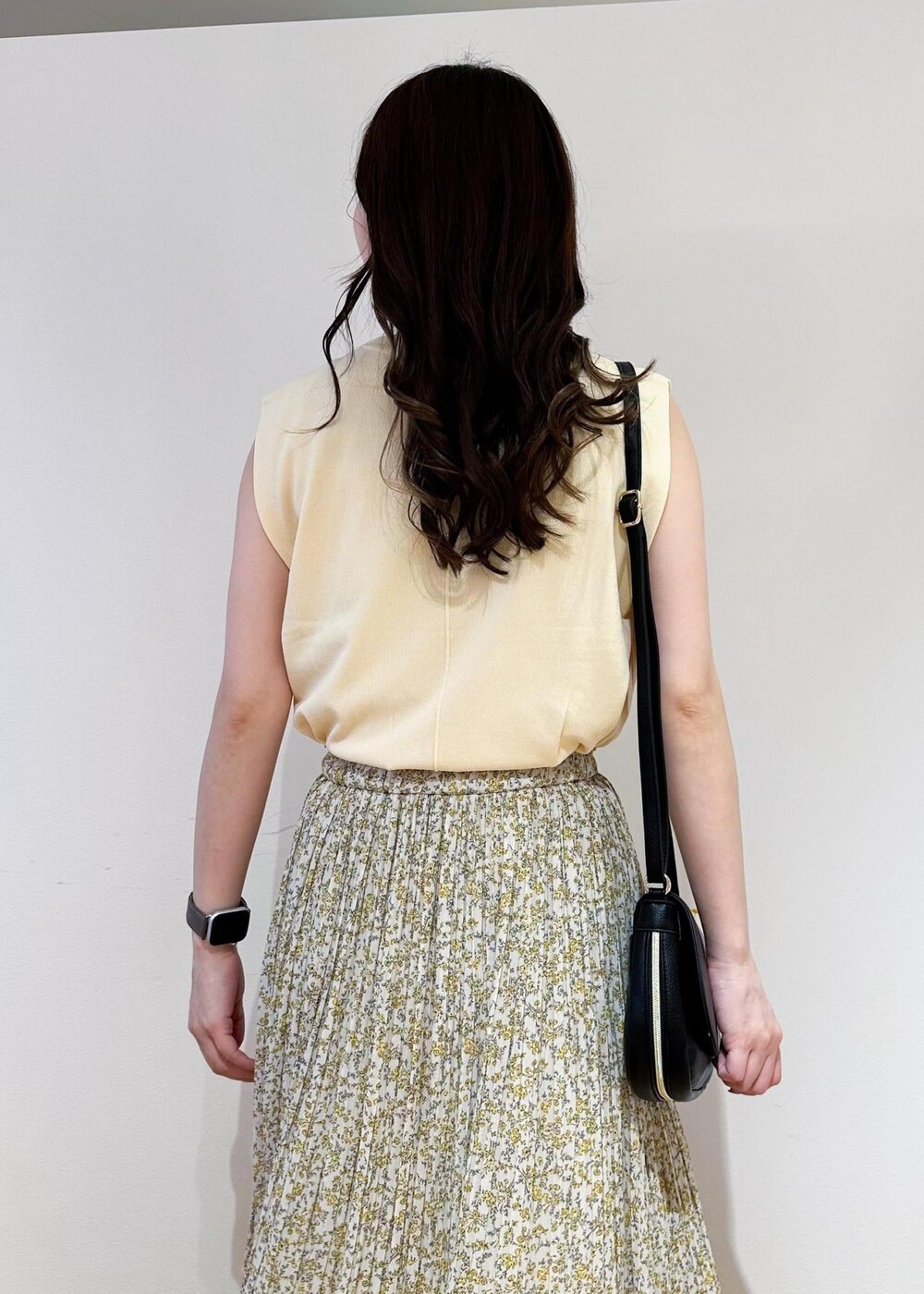 ベージュ系のニット/セーター、イエロー系のスカート、ブラック系のショルダーバッグを着用したレディースの春コーディネートの5枚目の写真