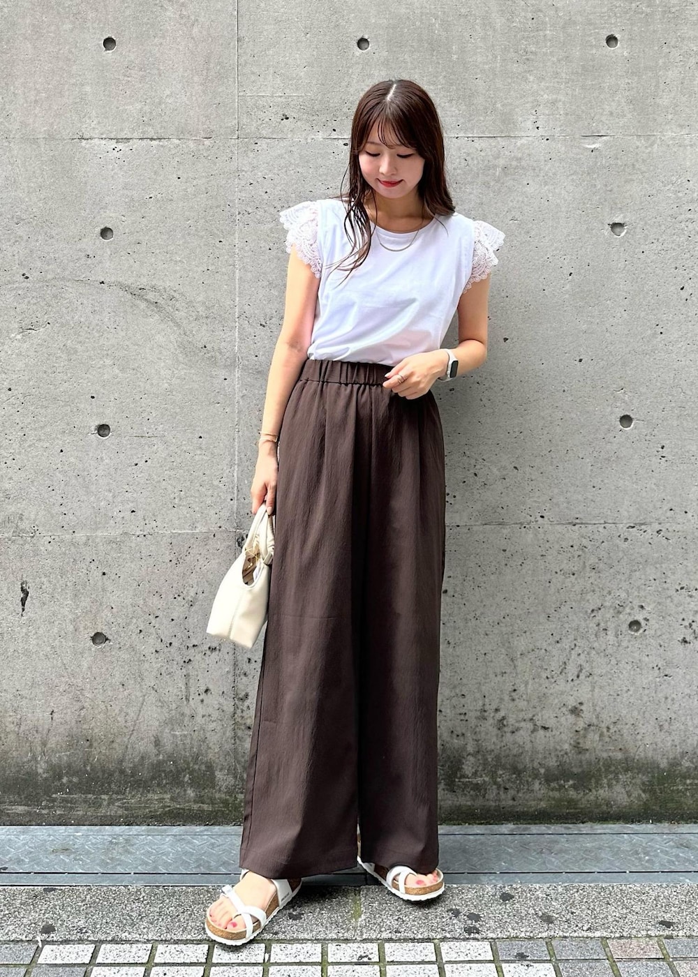 ホワイト系のショルダーバッグ、ホワイト系のTシャツ/カットソー、ブラウン系のその他パンツを着用したレディースの秋コーディネートの2枚目の写真