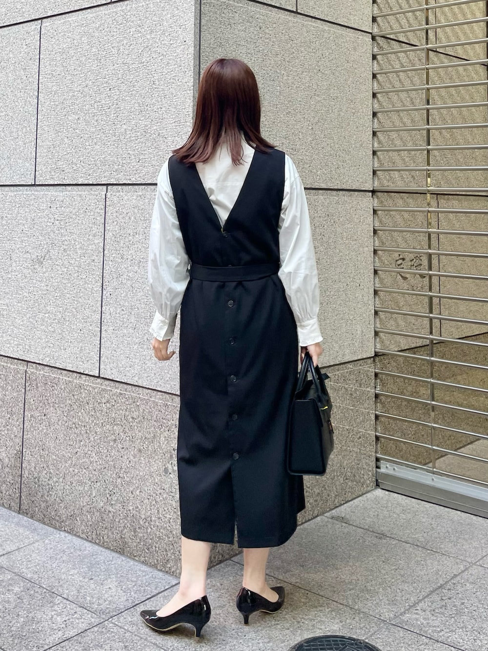 ホワイト系のシャツ/ブラウス、ブラック系のジャンパースカート、ブラック系のパンプスを着用したレディースの冬コーディネートの2枚目の写真