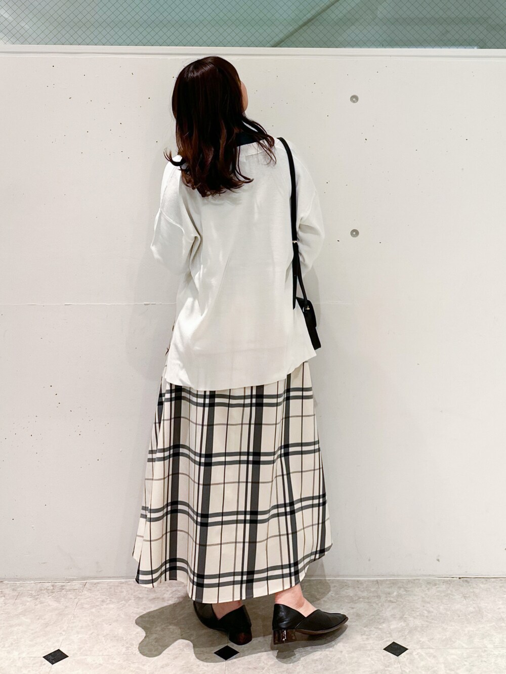 ホワイト系のカーディガン/ボレロ、グリーン系のニット/セーター、ホワイト系のスカートを着用したレディースの冬コーディネートの2枚目の写真