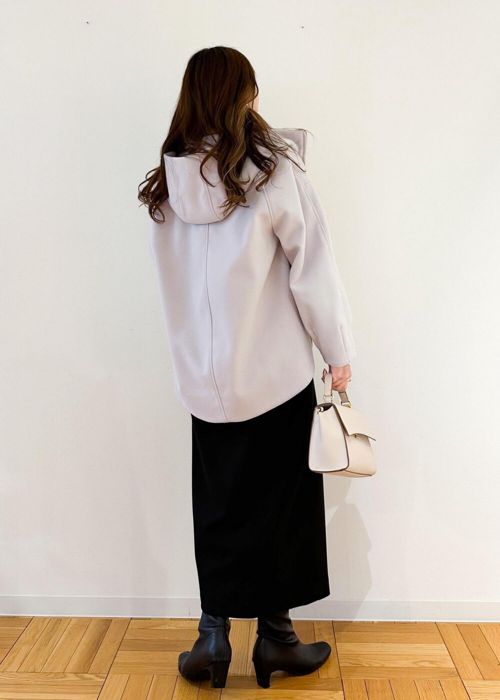 グレー系のその他アウター、ホワイト系のショルダーバッグ、ブラック系のスカートを着用したレディースの冬コーディネートの3枚目の写真