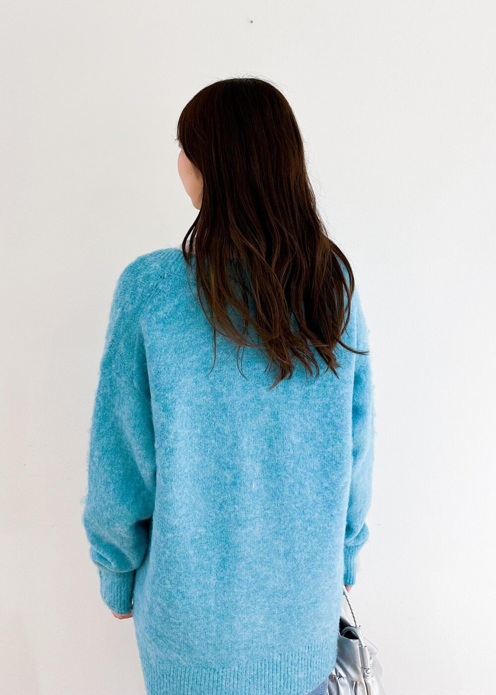 シルバー系のトートバッグ、ホワイト系のシャツ/ブラウス、グリーン系のカーディガン/ボレロを着用したレディースの秋コーディネートの5枚目の写真