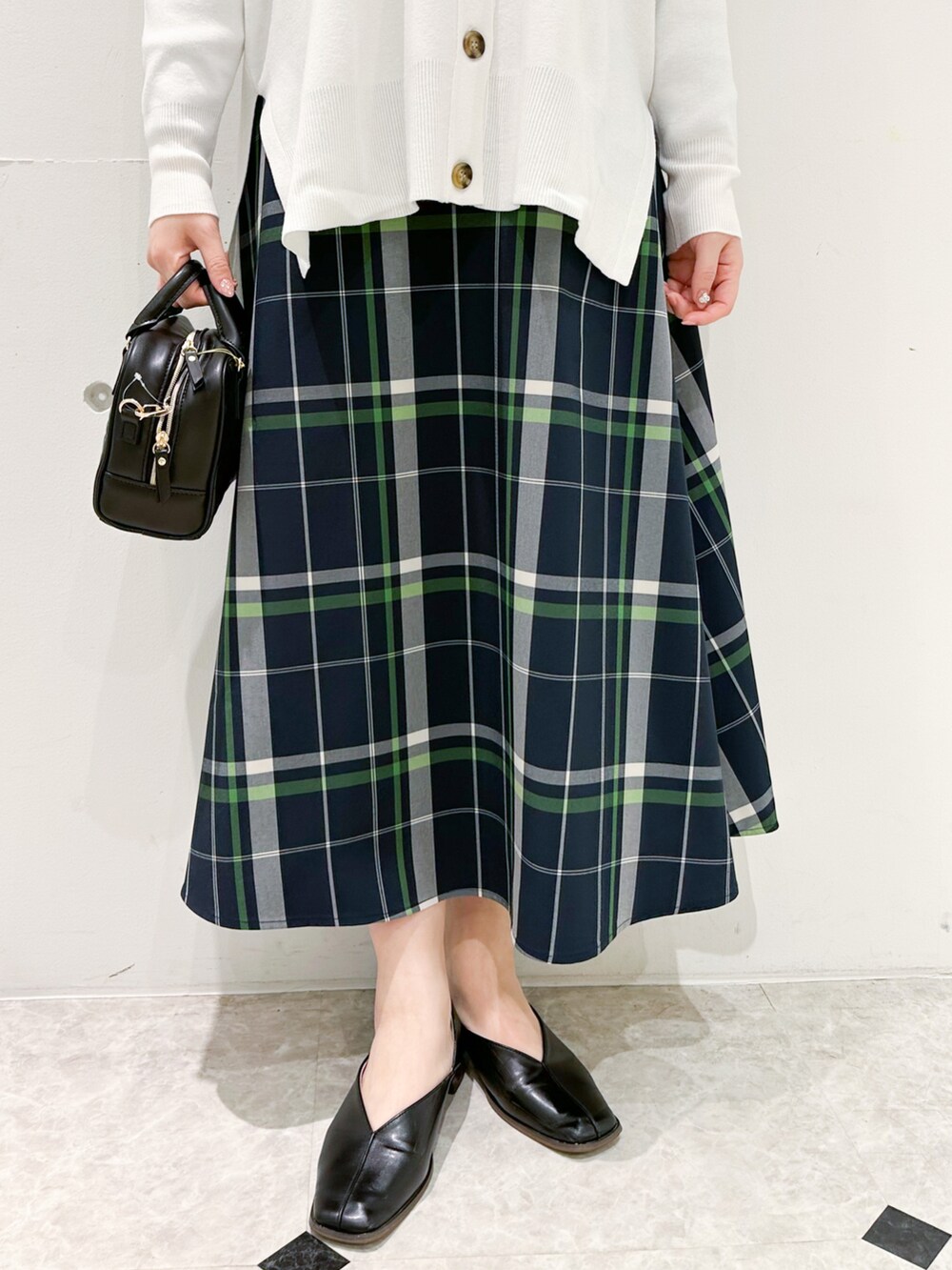 ホワイト系のカーディガン/ボレロ、グリーン系のニット/セーター、ホワイト系のスカートを着用したレディースの冬コーディネートの5枚目の写真