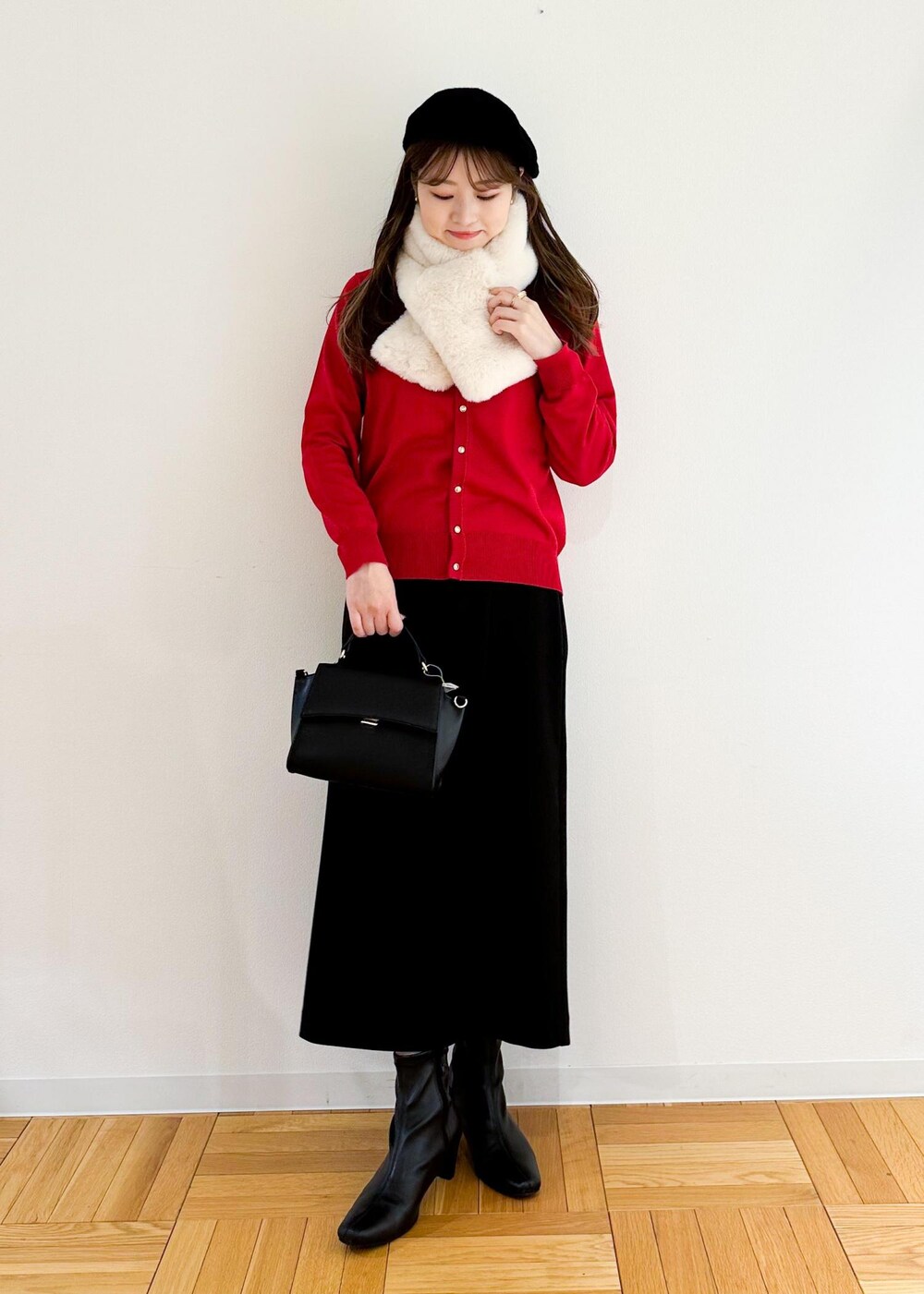 レッド系のカーディガン/ボレロ、ブラック系のショルダーバッグ、ブラック系のスカートを着用したレディースの冬コーディネートの2枚目の写真