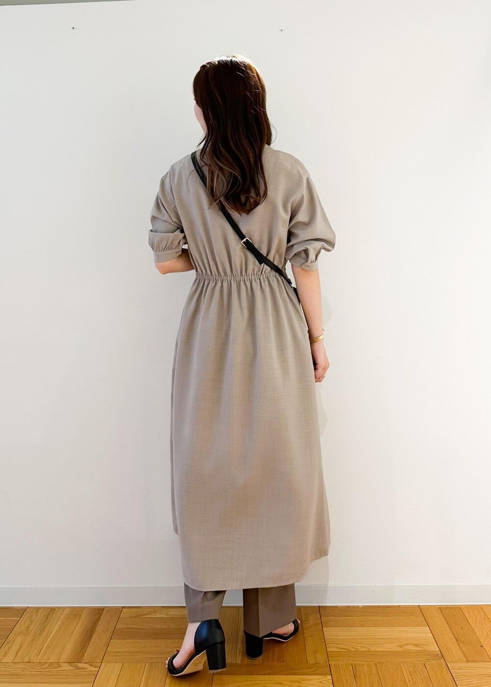 ブラック系のショルダーバッグ、ベージュ系のワンピース、ブラウン系のその他パンツを着用したレディースの夏コーディネートの3枚目の写真