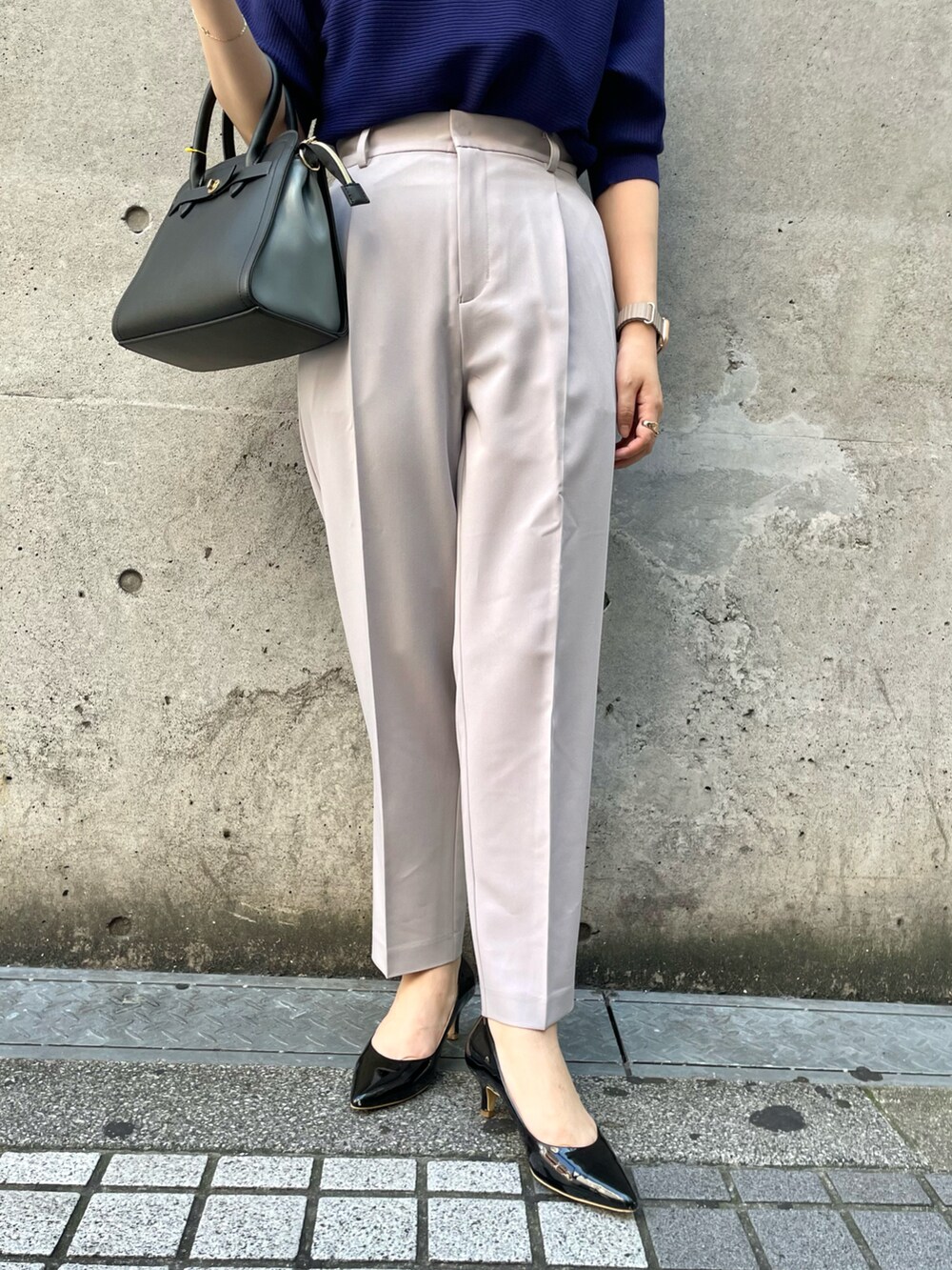 パープル系のニット/セーター、グレー系のその他パンツ、ブラック系のショルダーバッグを着用したレディースの秋コーディネートの5枚目の写真