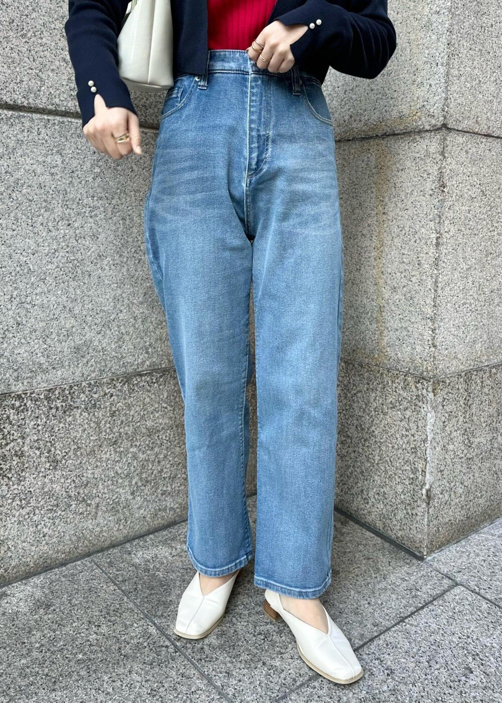 レッド系のニット/セーター、ブルー系のデニムパンツ、ブルー系のカーディガン/ボレロを着用したレディースの冬コーディネートの6枚目の写真