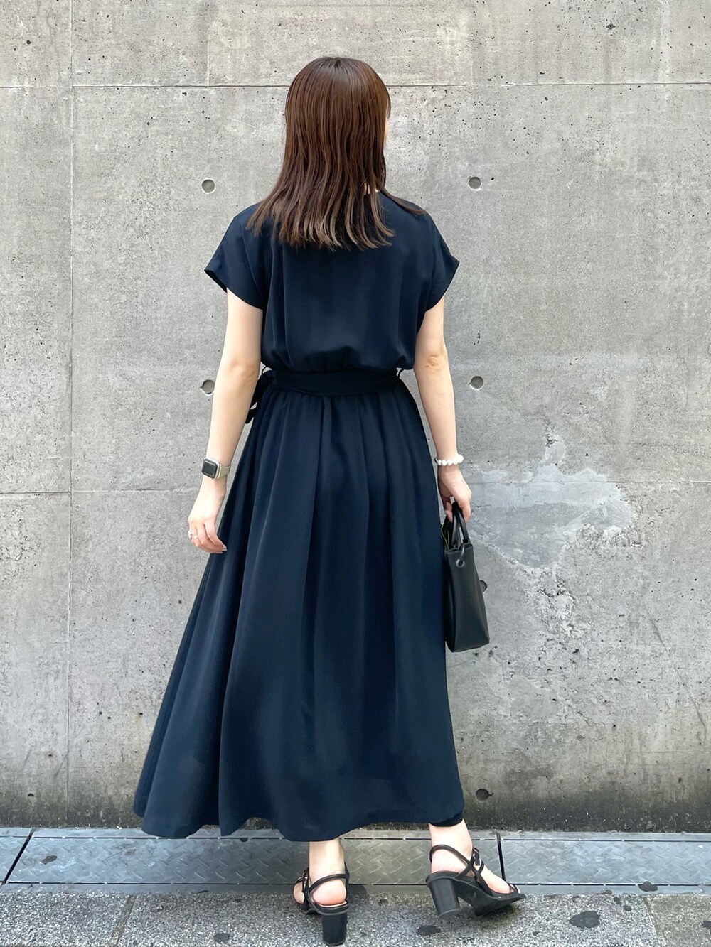 ブルー系のワンピース、ブラック系のショルダーバッグを着用したレディースの夏コーディネートの2枚目の写真