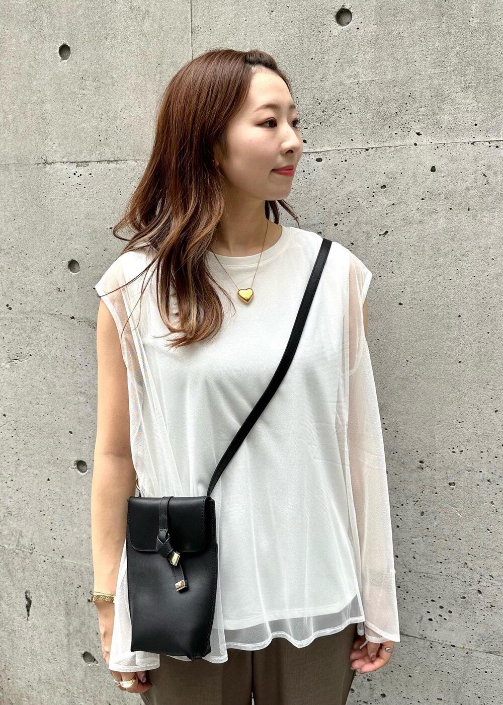 ブラック系のショルダーバッグ、ブラウン系のその他パンツ、ホワイト系のTシャツ/カットソーを着用したレディースの夏コーディネートの4枚目の写真