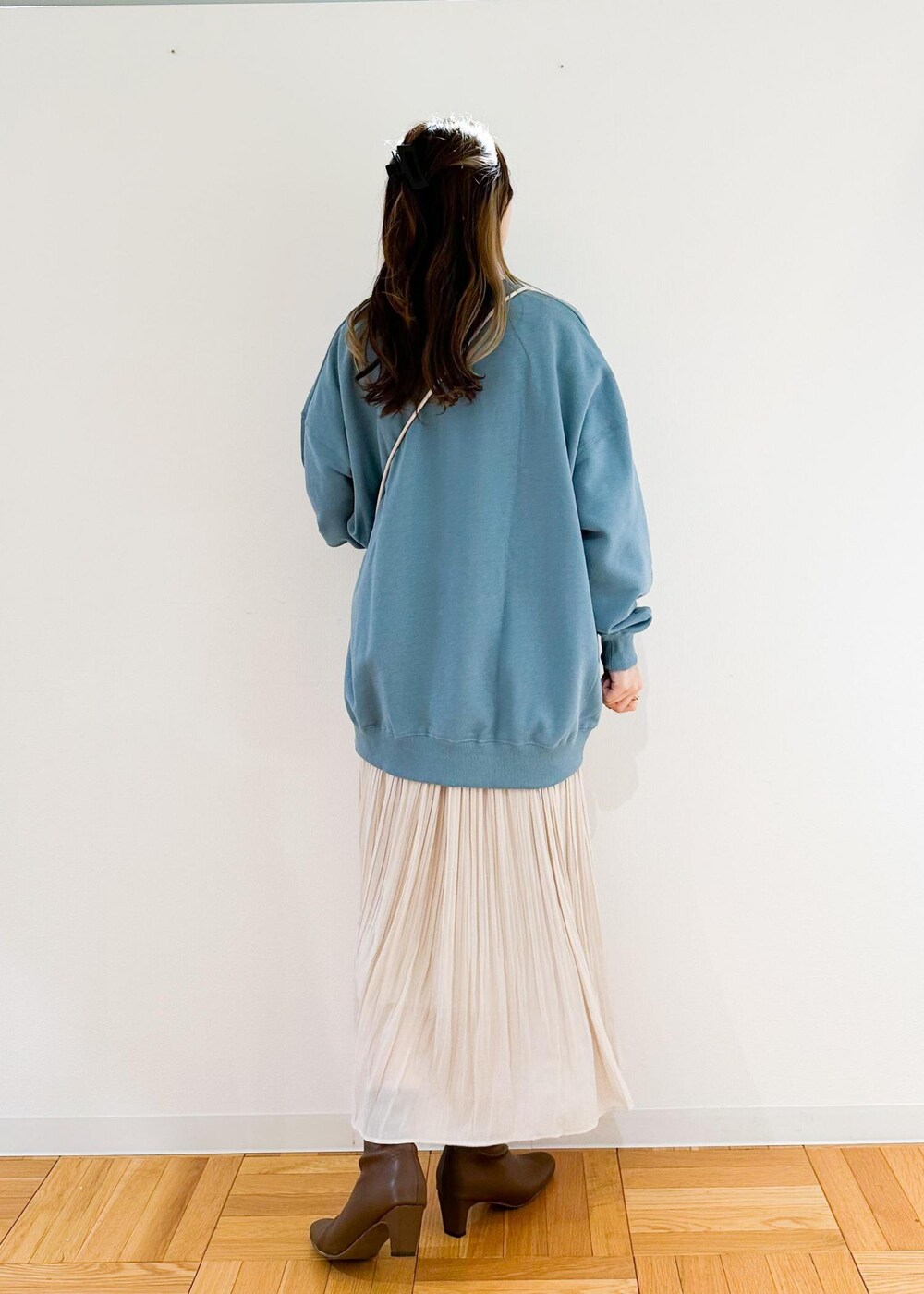 ベージュ系のスカート、ホワイト系のショルダーバッグ、グリーン系のスウェットを着用したレディースの秋コーディネートの3枚目の写真