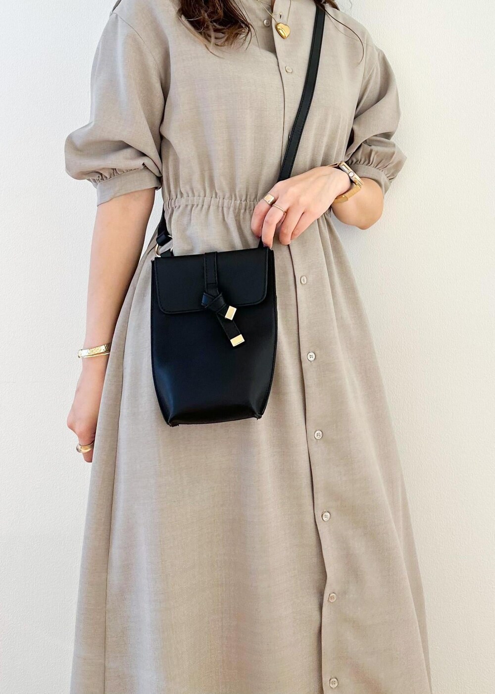 ブラック系のショルダーバッグ、ベージュ系のワンピース、ブラウン系のその他パンツを着用したレディースの夏コーディネートの6枚目の写真