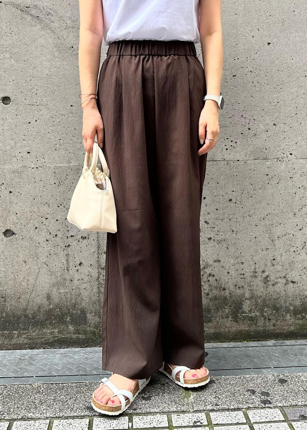 ホワイト系のショルダーバッグ、ホワイト系のTシャツ/カットソー、ブラウン系のその他パンツを着用したレディースの秋コーディネートの7枚目の写真