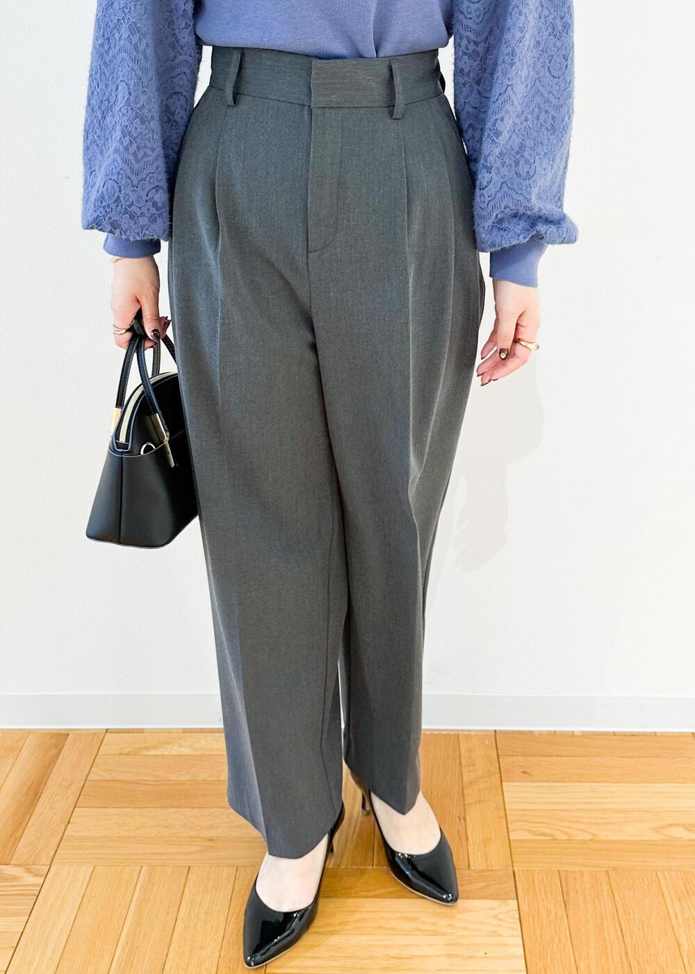 グレー系のその他パンツ、ブラック系のショルダーバッグ、ブルー系のニット/セーターを着用したレディースの秋コーディネートの7枚目の写真
