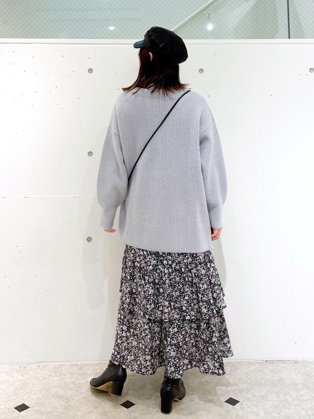 ブラック系のスカート、ブラック系のブーツ、ブルー系のニット/セーターを着用したレディースの冬コーディネートの2枚目の写真