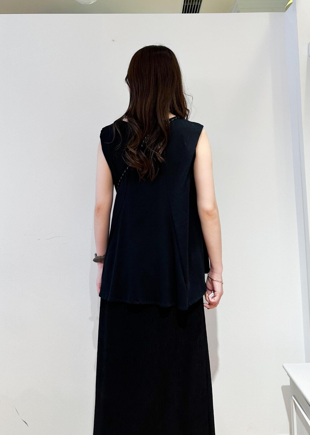 ホワイト系のショルダーバッグ、ブラック系のスカート、ホワイト系のサンダルを着用したレディースの春コーディネートの6枚目の写真