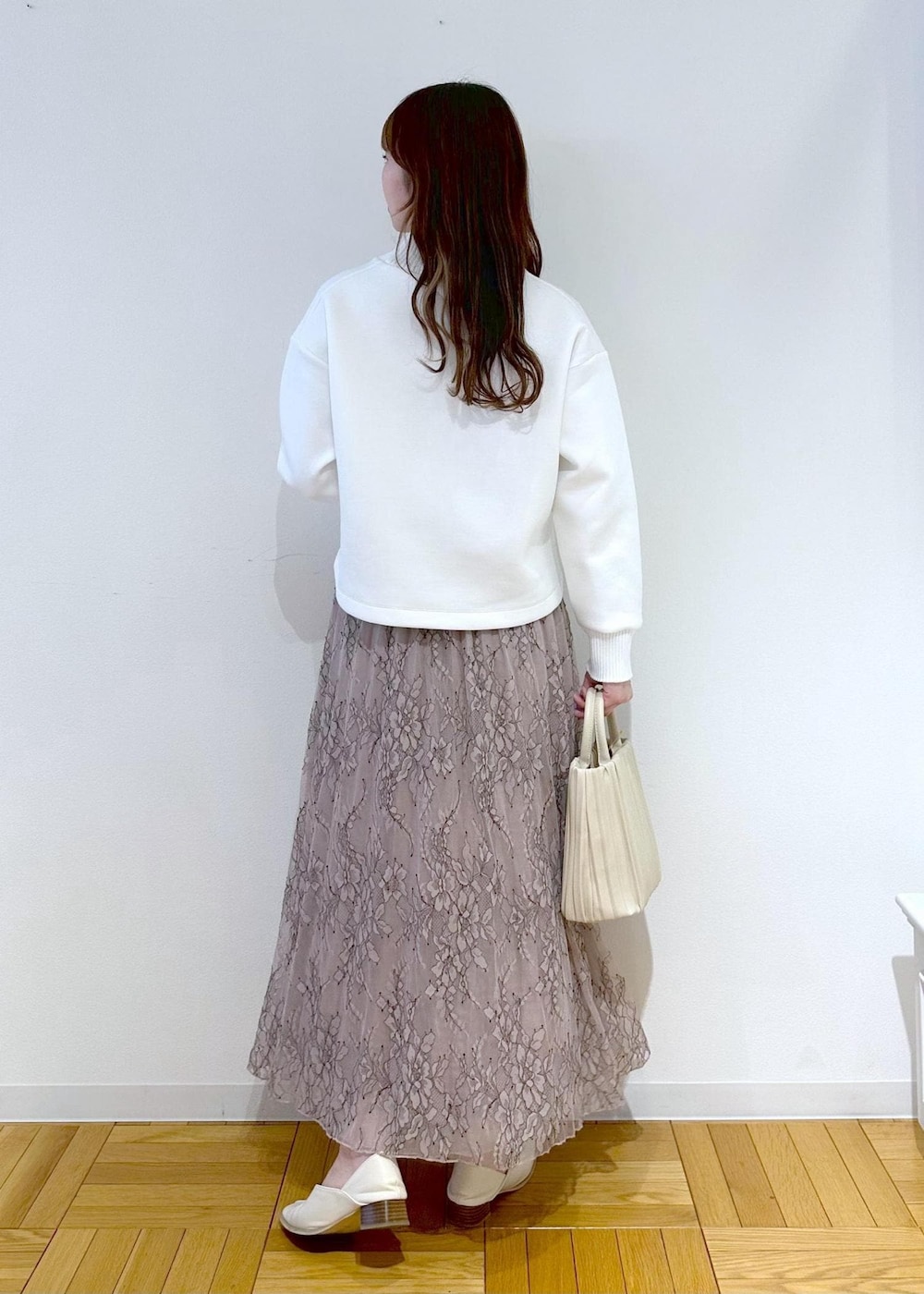 ホワイト系のハンドバッグ、ピンク系のスカート、ホワイト系のニット/セーターを着用したレディースの春コーディネートの3枚目の写真