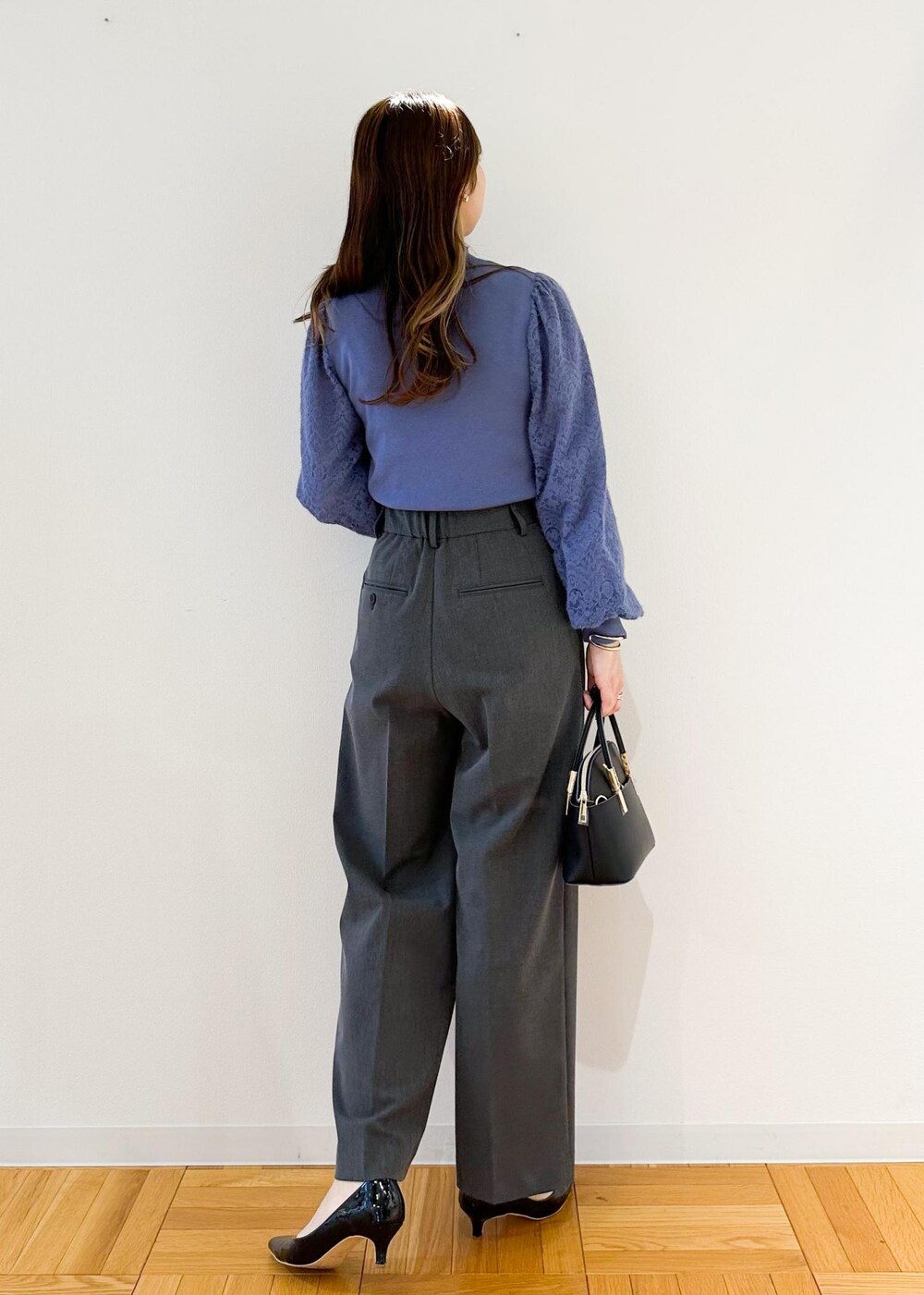 グレー系のその他パンツ、ブラック系のショルダーバッグ、ブルー系のニット/セーターを着用したレディースの秋コーディネートの3枚目の写真
