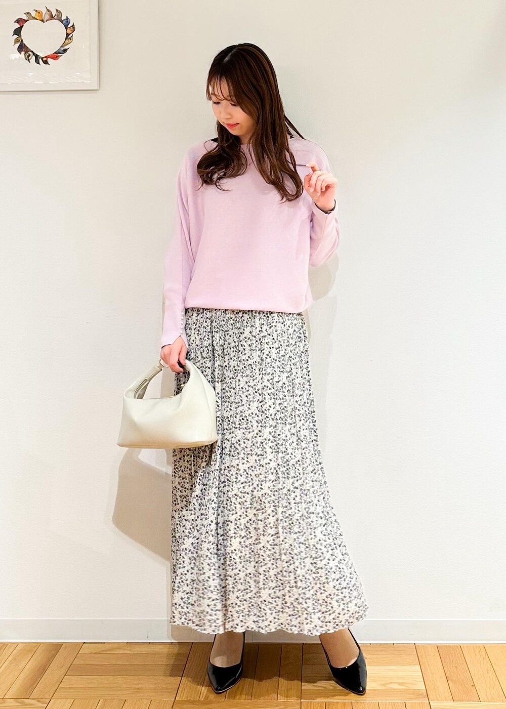 ベージュ系のスカート、ホワイト系のショルダーバッグ、ピンク系のニット/セーターを着用したレディースの冬コーディネートの2枚目の写真