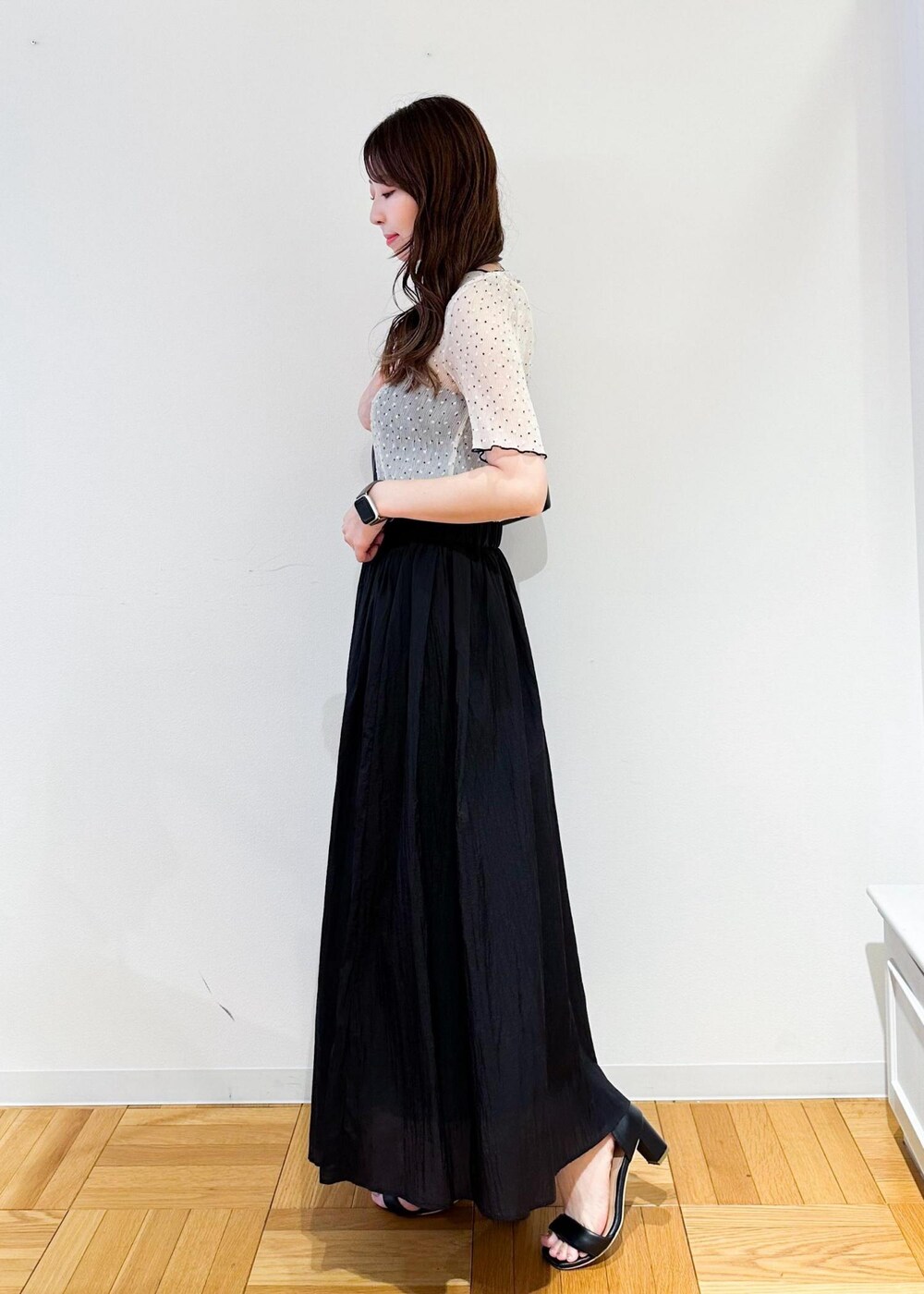 ブラック系のショルダーバッグ、グレー系のスカート、ホワイト系のシャツ/ブラウスを着用したレディースの夏コーディネートの3枚目の写真