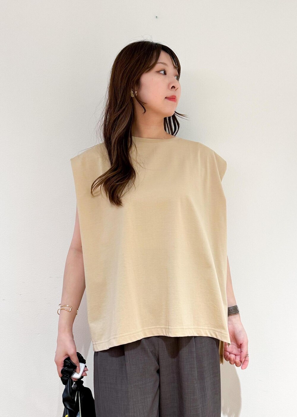 ベージュ系のTシャツ/カットソー、ブラウン系のその他パンツ、ブラック系のハンドバッグを着用したレディースの夏コーディネートの5枚目の写真