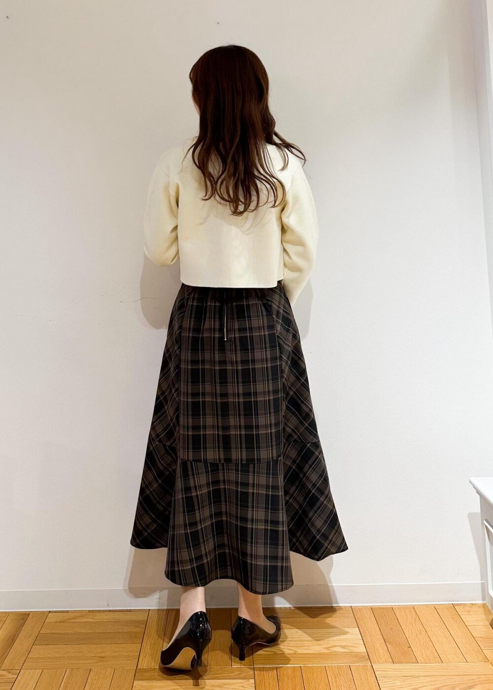 イエロー系のスカート、ベージュ系のシャツ/ブラウス、ホワイト系のカーディガン/ボレロを着用したレディースの冬コーディネートの4枚目の写真