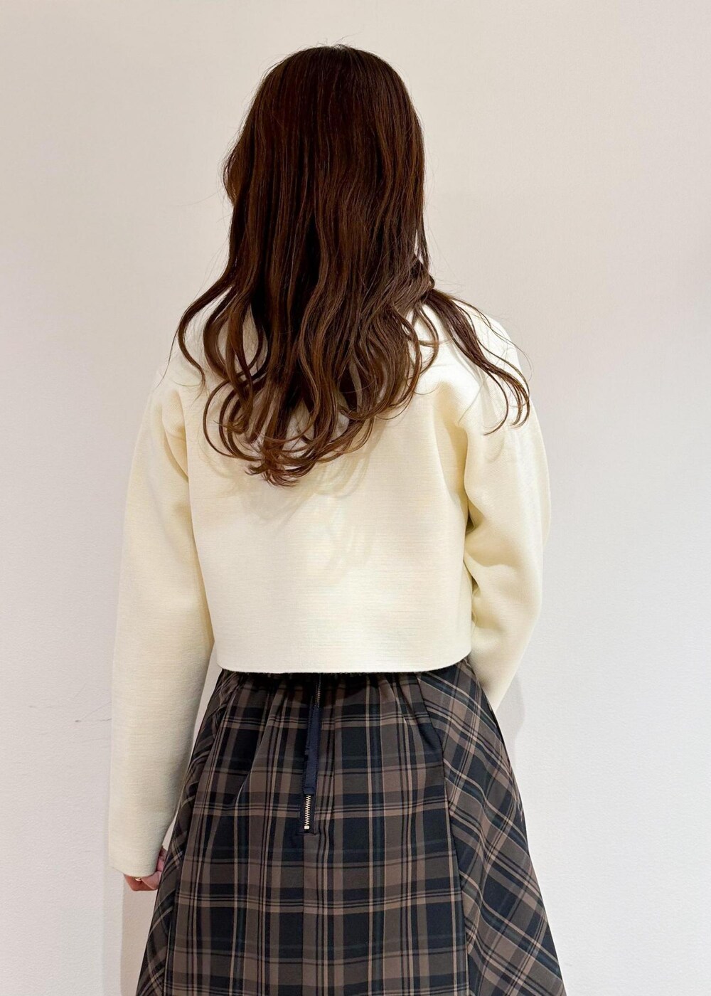 イエロー系のスカート、ベージュ系のシャツ/ブラウス、ホワイト系のカーディガン/ボレロを着用したレディースの冬コーディネートの6枚目の写真