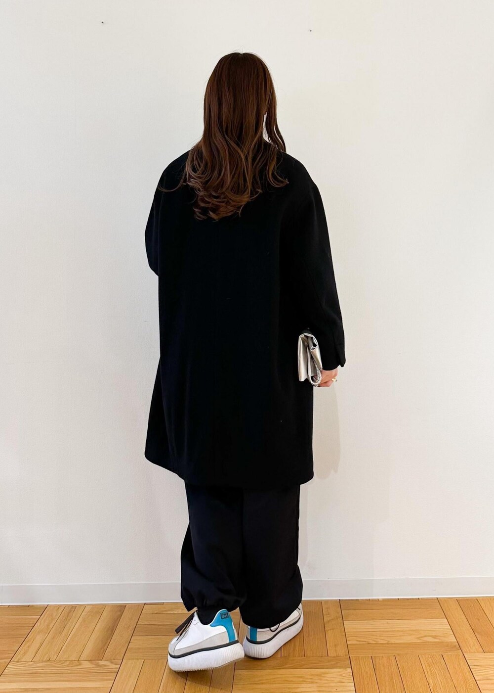 レッド系のTシャツ/カットソー、ブラック系のノーカラーコート、シルバー系のトートバッグを着用したレディースの冬コーディネートの3枚目の写真