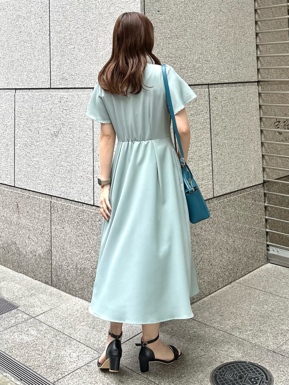 グリーン系のワンピース、ブルー系のショルダーバッグを着用したレディースの春コーディネートの2枚目の写真