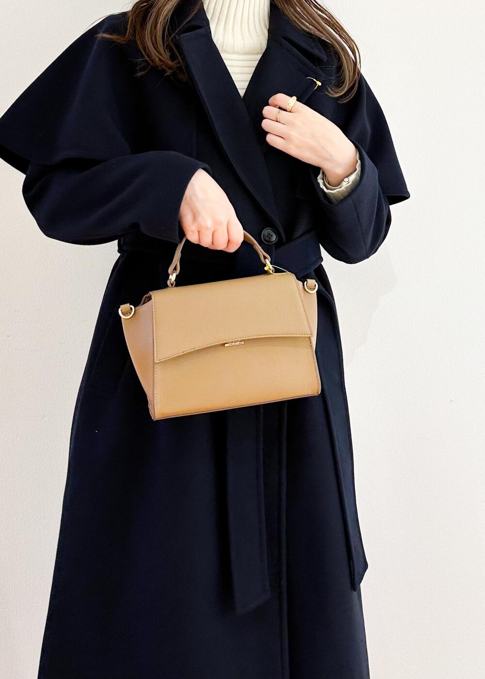 ホワイト系のニット/セーター、ブラウン系のショルダーバッグ、ブラック系のスカートを着用したレディースの秋コーディネートの6枚目の写真