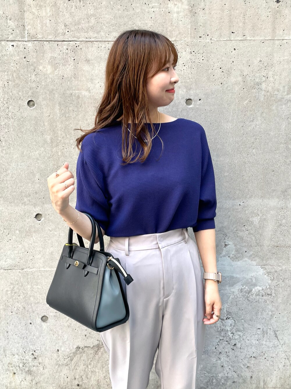 パープル系のニット/セーター、グレー系のその他パンツ、ブラック系のショルダーバッグを着用したレディースの秋コーディネートの3枚目の写真