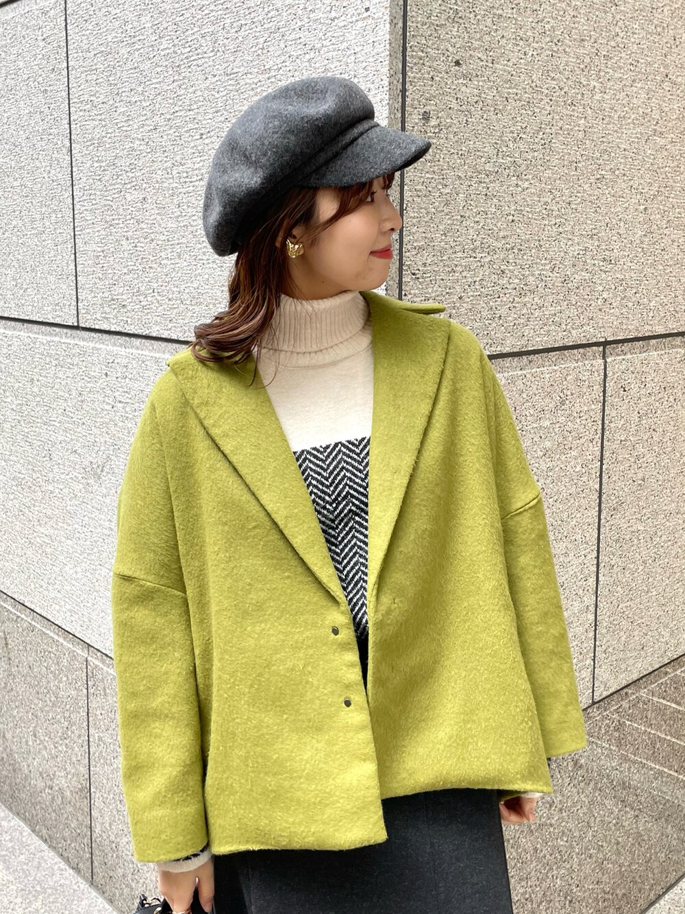 イエロー系のその他アウター、ブラック系のニット/セーター、ブラック系のショルダーバッグを着用したレディースの冬コーディネートの3枚目の写真