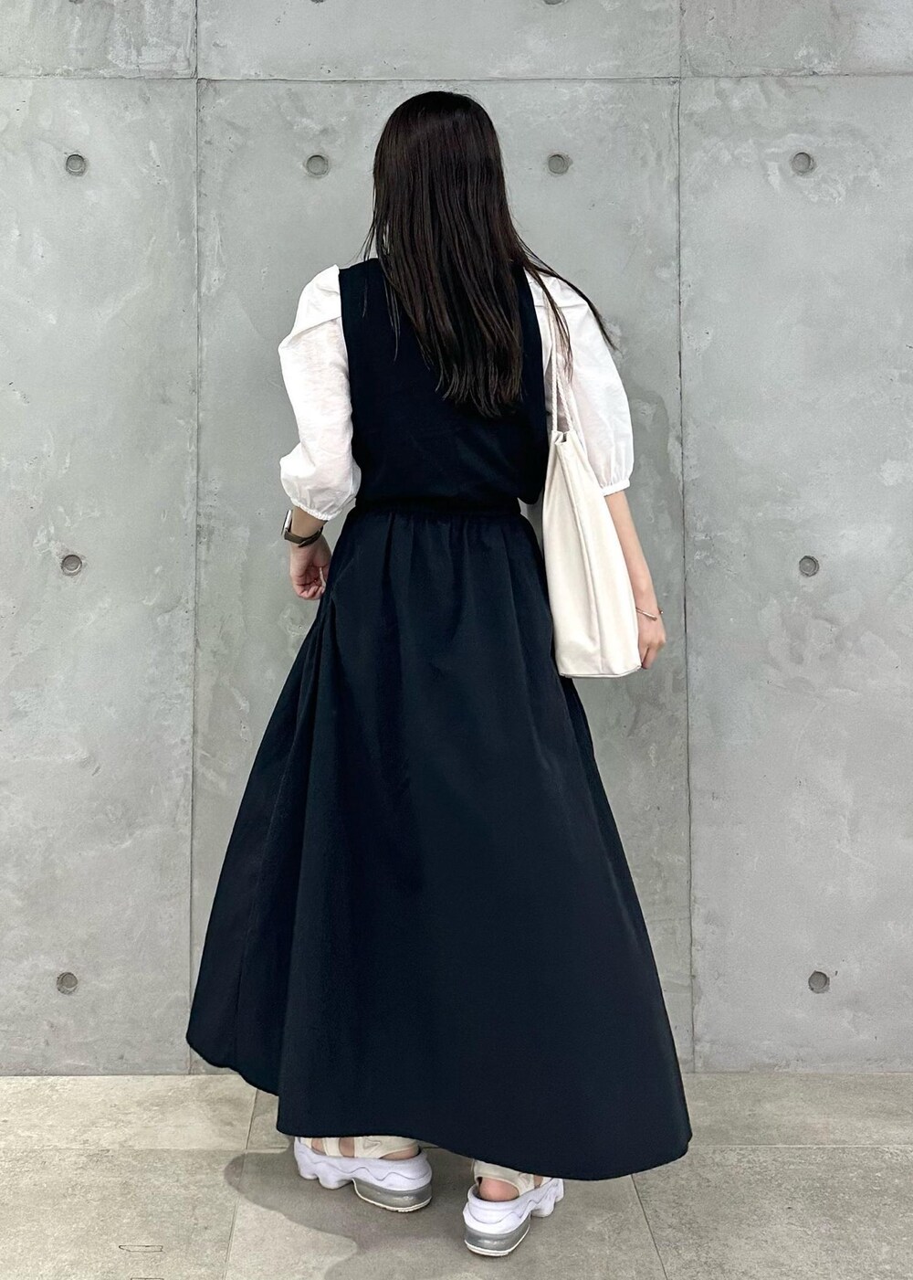 ホワイト系のトートバッグ、ブラック系のスカート、ブラック系のTシャツ/カットソーを着用したレディースの夏コーディネートの3枚目の写真