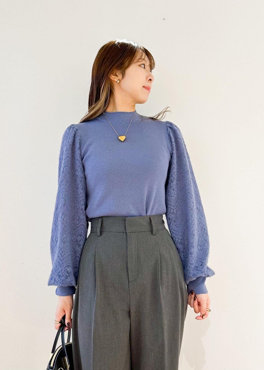 グレー系のその他パンツ、ブラック系のショルダーバッグ、ブルー系のニット/セーターを着用したレディースの秋コーディネートの4枚目の写真
