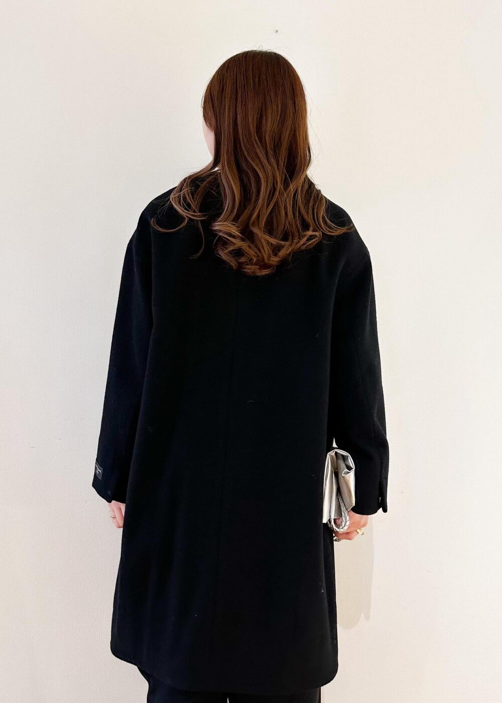 レッド系のTシャツ/カットソー、ブラック系のノーカラーコート、シルバー系のトートバッグを着用したレディースの冬コーディネートの5枚目の写真