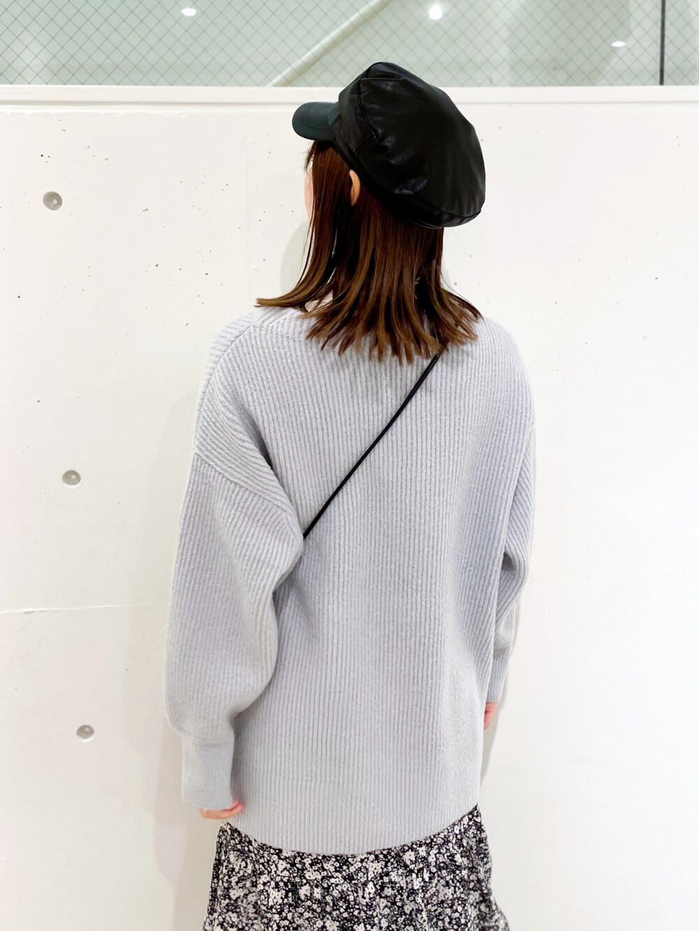 ブラック系のスカート、ブラック系のブーツ、ブルー系のニット/セーターを着用したレディースの冬コーディネートの4枚目の写真