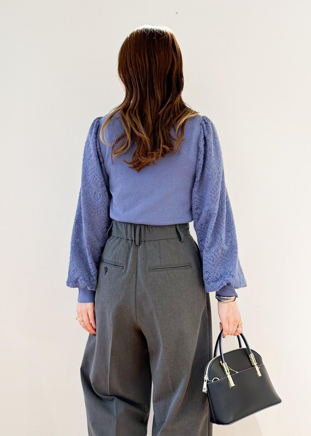 グレー系のその他パンツ、ブラック系のショルダーバッグ、ブルー系のニット/セーターを着用したレディースの秋コーディネートの5枚目の写真