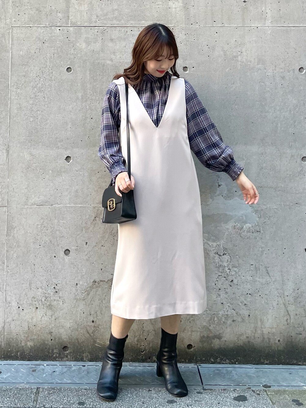 グレー系のその他アウター、ベージュ系のジャンパースカート、ブラック系のショルダーバッグを着用したレディースの秋コーディネートの3枚目の写真