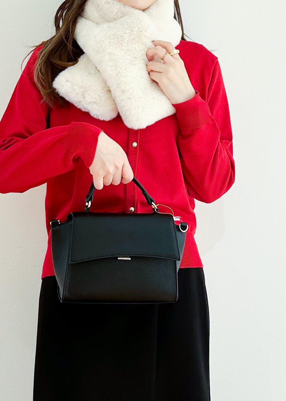 レッド系のカーディガン/ボレロ、ブラック系のショルダーバッグ、ブラック系のスカートを着用したレディースの冬コーディネートの6枚目の写真