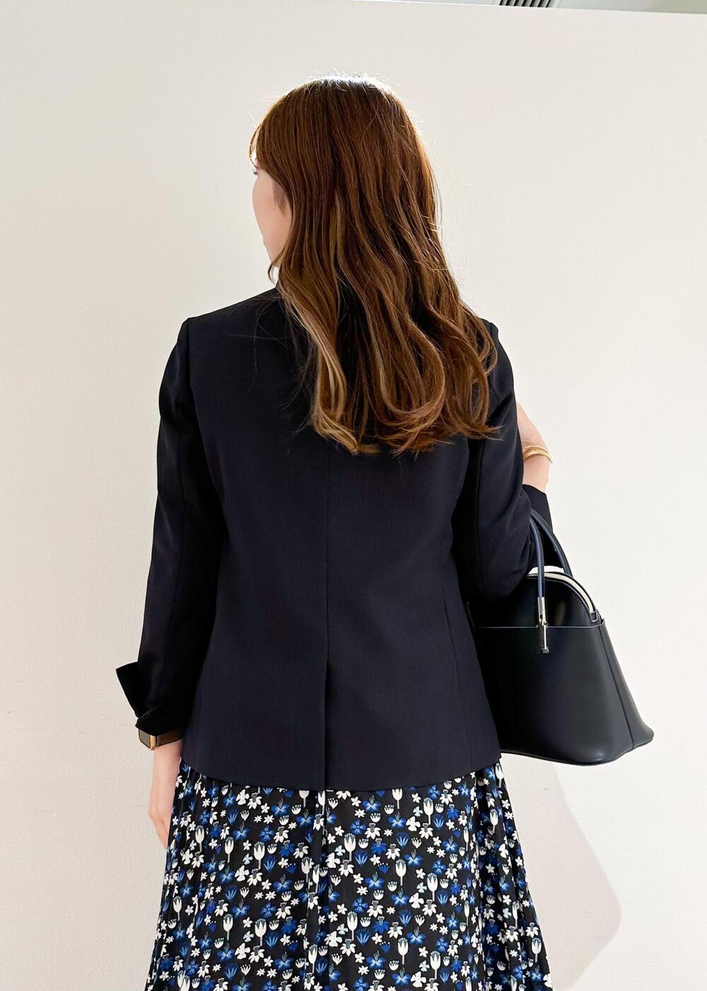 ブラック系のショルダーバッグ、ホワイト系のシャツ/ブラウス、ブルー系のテーラードジャケットを着用したレディースの秋コーディネートの5枚目の写真