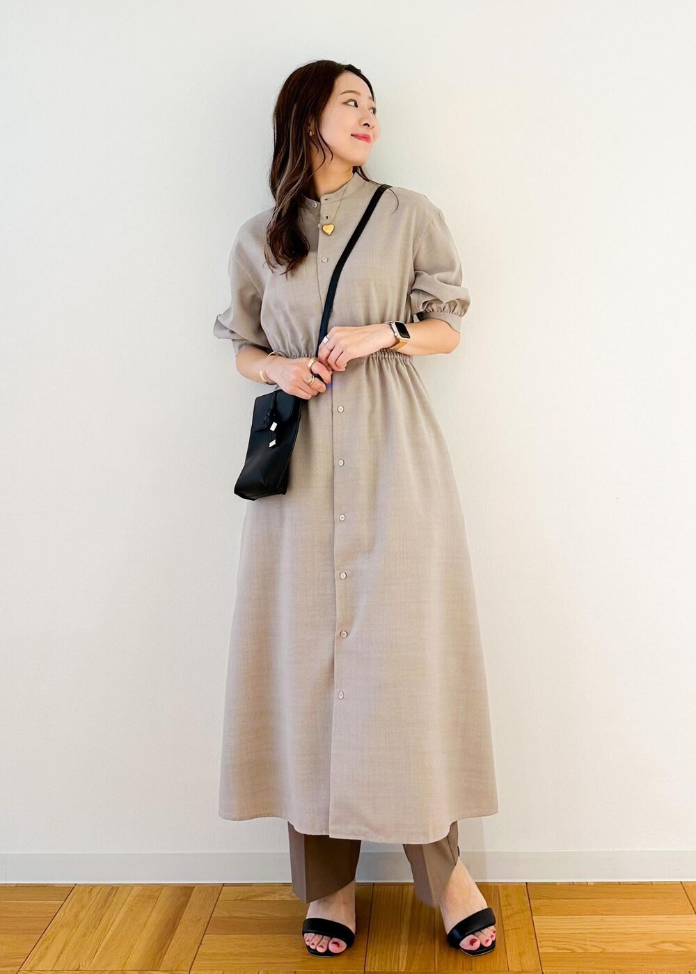 ブラック系のショルダーバッグ、ベージュ系のワンピース、ブラウン系のその他パンツを着用したレディースの夏コーディネートの2枚目の写真