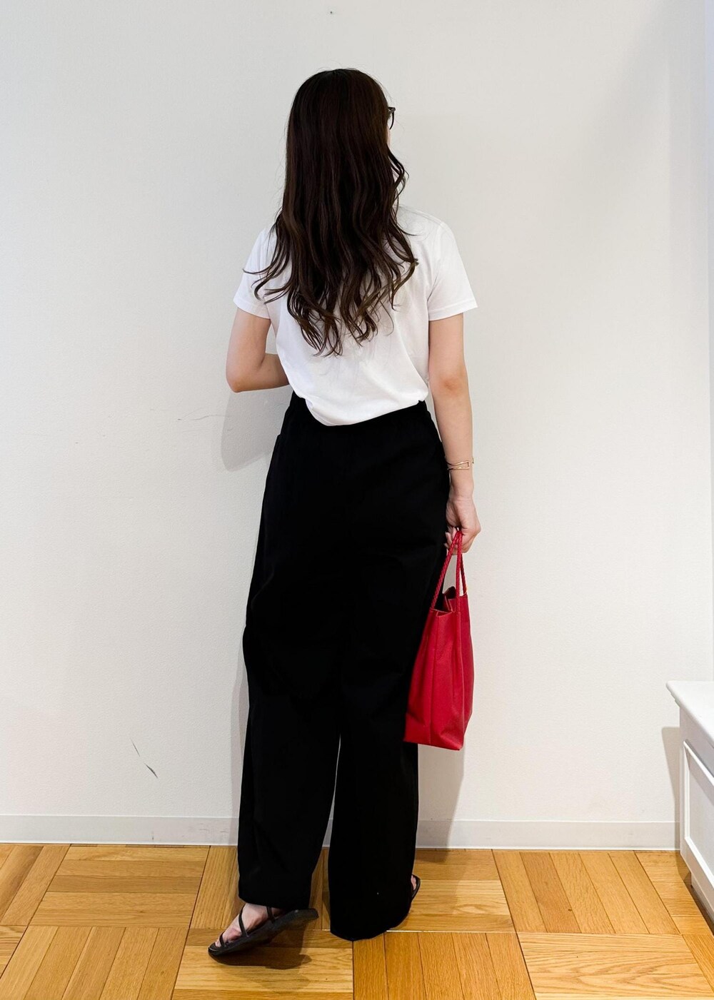 ブラック系のその他パンツ、ホワイト系のTシャツ/カットソー、レッド系のトートバッグを着用したレディースの夏コーディネートの3枚目の写真