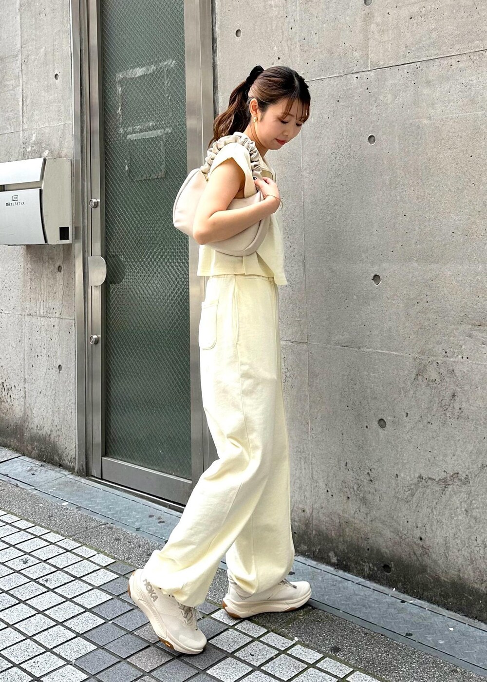 ホワイト系のTシャツ/カットソー、ホワイト系のスウェットパンツ、ホワイト系のハンドバッグを着用したレディースの春コーディネートの4枚目の写真