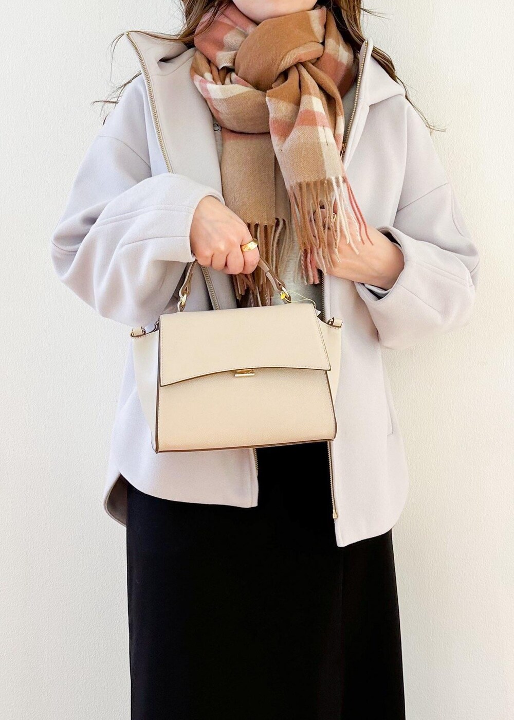 グレー系のその他アウター、ホワイト系のショルダーバッグ、ブラック系のスカートを着用したレディースの冬コーディネートの6枚目の写真