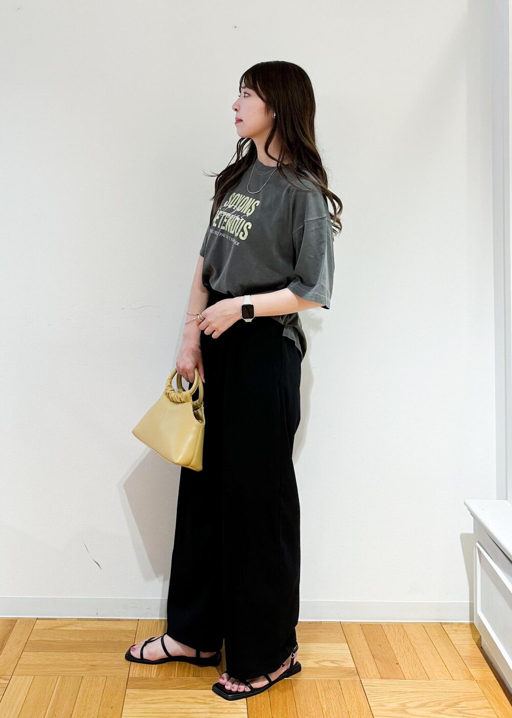 イエロー系のショルダーバッグ、グレー系のTシャツ/カットソー、ブラック系のその他パンツを着用したレディースの秋コーディネートの3枚目の写真