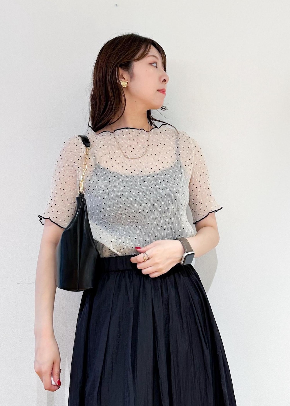 ブラック系のショルダーバッグ、グレー系のスカート、ホワイト系のシャツ/ブラウスを着用したレディースの夏コーディネートの5枚目の写真