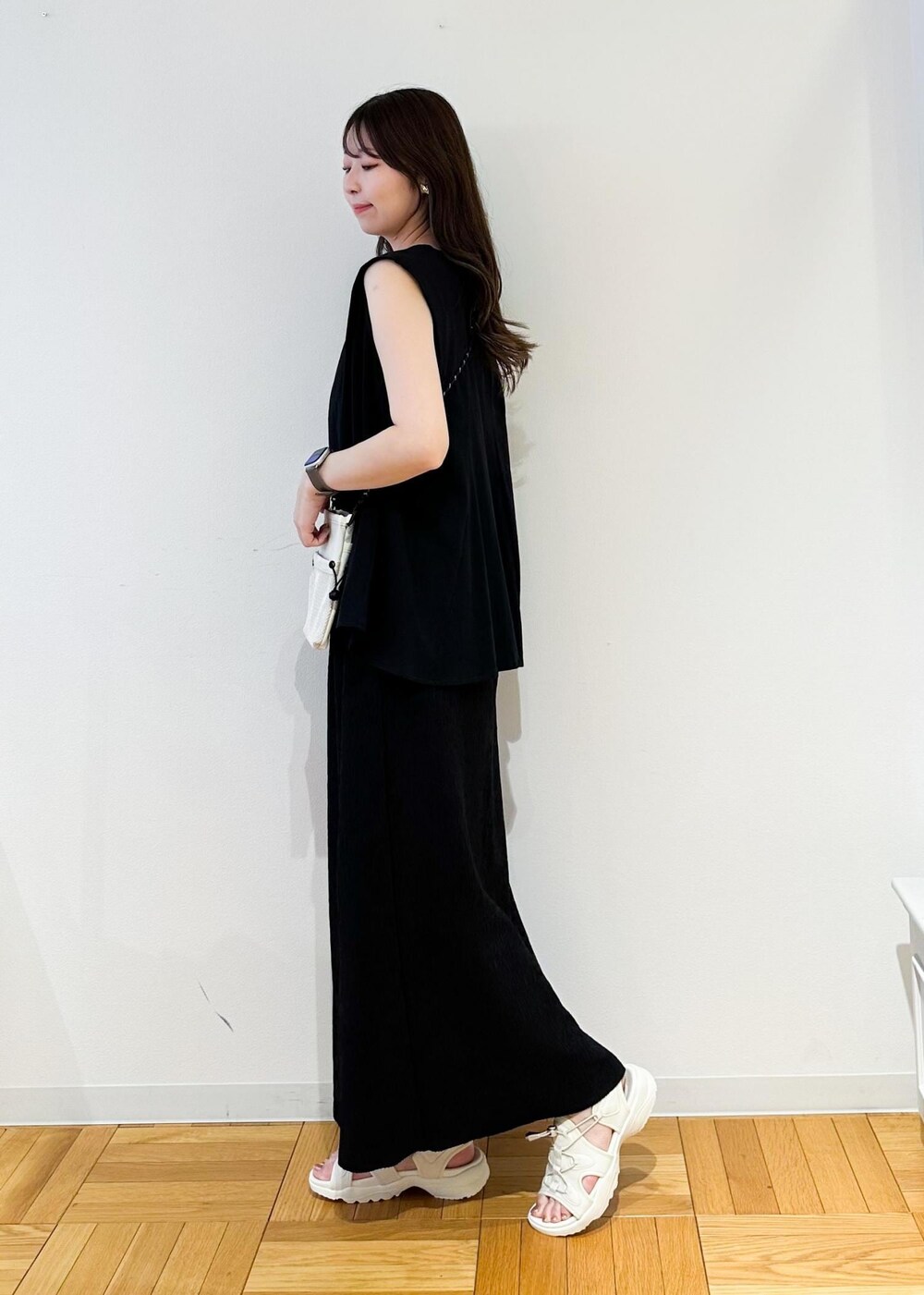 ホワイト系のショルダーバッグ、ブラック系のスカート、ホワイト系のサンダルを着用したレディースの春コーディネートの3枚目の写真