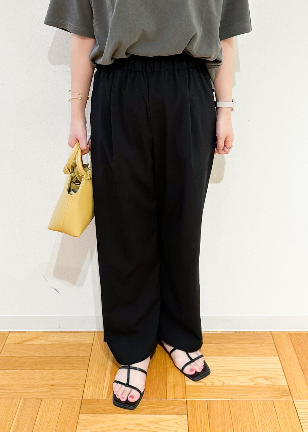 イエロー系のショルダーバッグ、グレー系のTシャツ/カットソー、ブラック系のその他パンツを着用したレディースの秋コーディネートの7枚目の写真