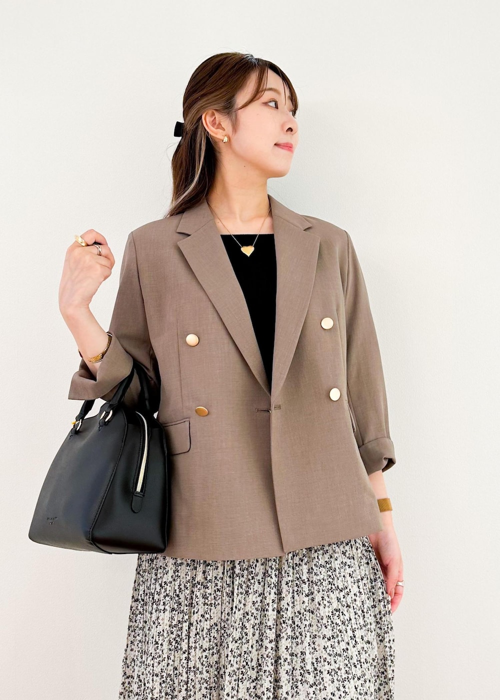 ベージュ系のスカート、ホワイト系のボストンバッグ、ブラウン系のテーラードジャケットを着用したレディースの夏コーディネートの4枚目の写真