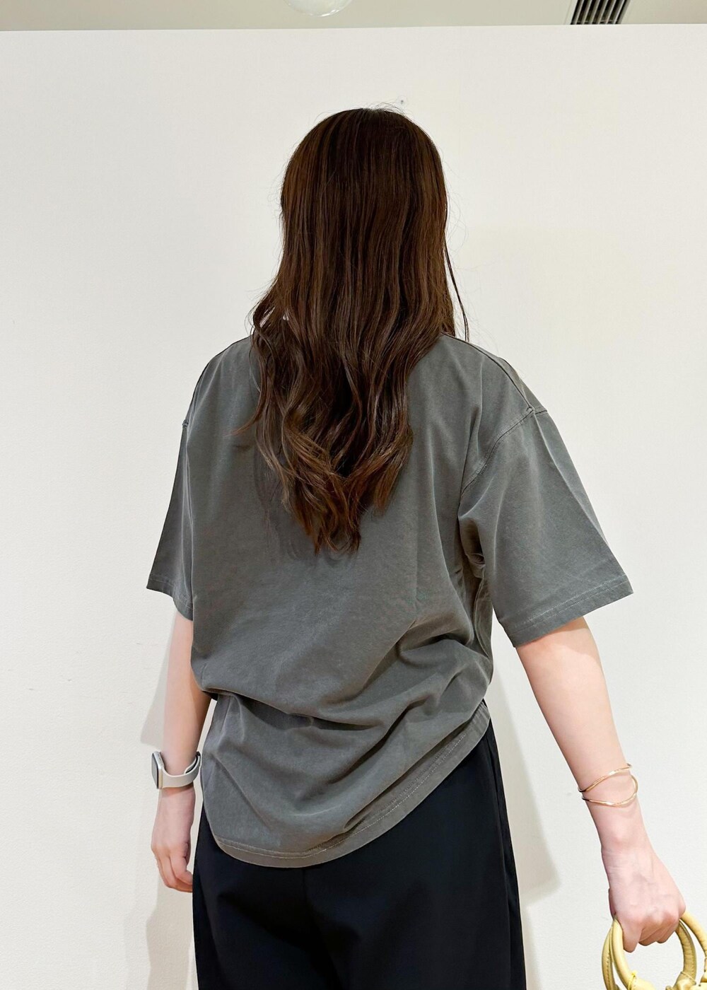 イエロー系のショルダーバッグ、グレー系のTシャツ/カットソー、ブラック系のその他パンツを着用したレディースの秋コーディネートの6枚目の写真